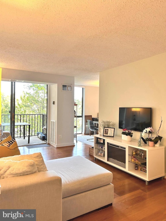 2300 Pimmit Dr Unit 601, Falls Church, VA 22043 - living area with wood finished floors, visible vents, and a textured ceiling