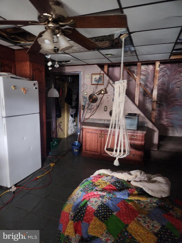 interior space with freestanding refrigerator and a ceiling fan
