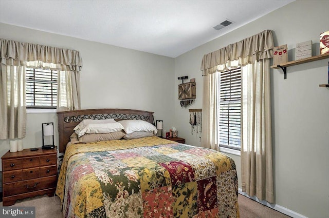 carpeted bedroom featuring visible vents and baseboards