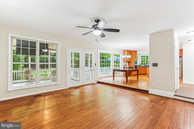 9409 Emory Grove Rd, Gaithersburg, MD 20877 - unfurnished living room featuring a ceiling fan, a chandelier, baseboards, and light wood-type flooring