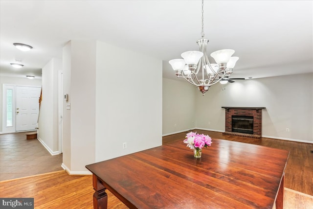 9409 Emory Grove Rd, Gaithersburg, MD 20877 - dining space featuring a chandelier, baseboards, a brick fireplace, and light wood-style floors