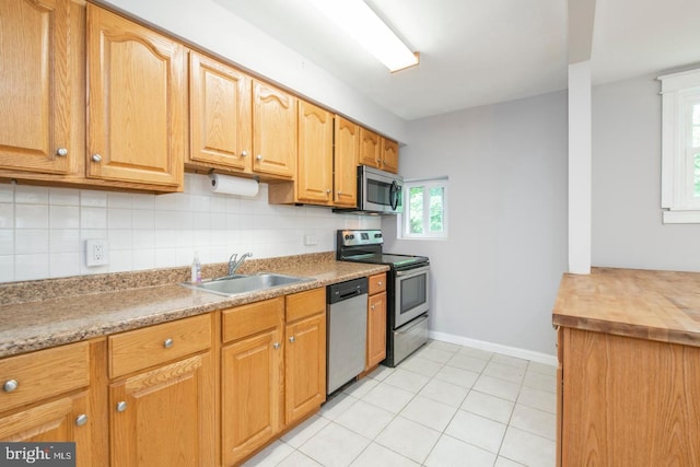 763 Humphreys Rd, Ardmore, PA 19003 - kitchen with appliances with stainless steel finishes, a sink, backsplash, baseboards, and light tile patterned floors