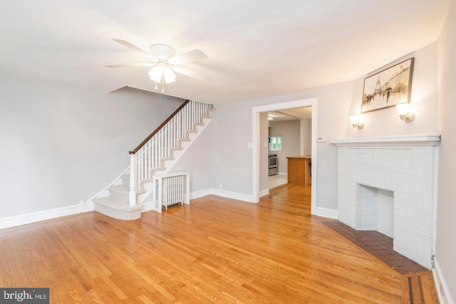 763 Humphreys Rd, Ardmore, PA 19003 - unfurnished living room with light wood-style floors, stairway, ceiling fan, a brick fireplace, and baseboards