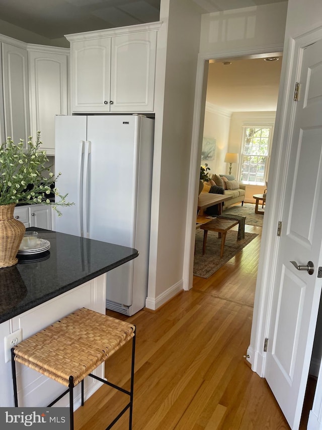 15 Franklin St, Alexandria, VA 22314 - kitchen featuring freestanding refrigerator, white cabinets, light wood-style floors, and baseboards