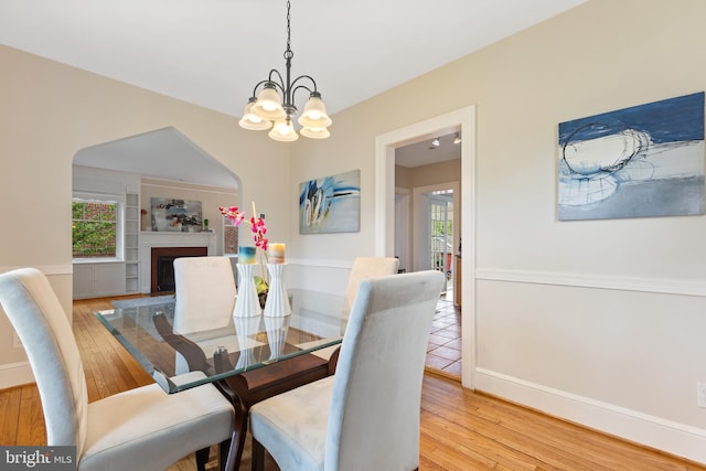 1412 N Wakefield St, Arlington, VA 22207 - dining space featuring a fireplace with flush hearth, light wood-type flooring, baseboards, and an inviting chandelier