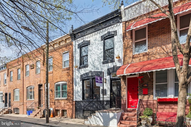 townhome / multi-family property featuring brick siding and entry steps