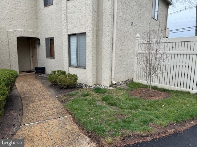 view of home's exterior featuring stucco siding and fence