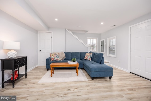 living room with light wood-style flooring, electric panel, visible vents, recessed lighting, and baseboards