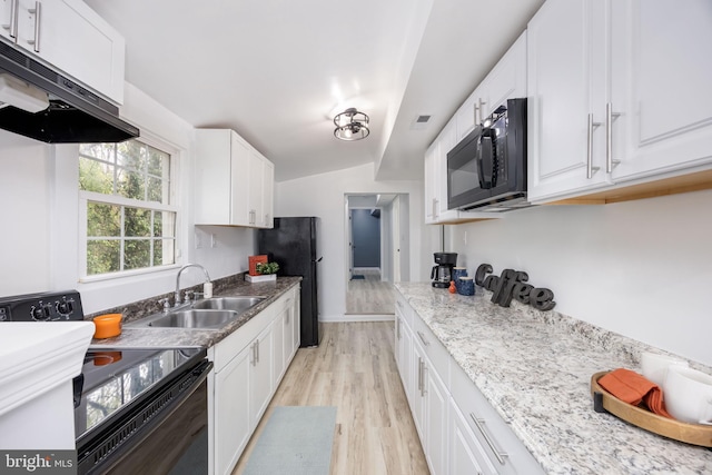 kitchen with white cabinets, under cabinet range hood, black appliances, light wood-style floors, and a sink