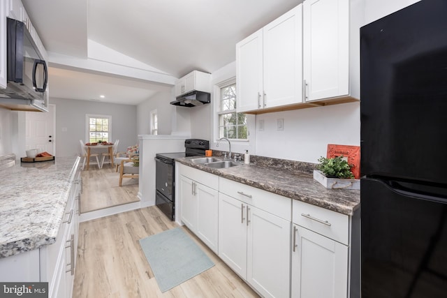 kitchen featuring a sink, light wood-type flooring, black appliances, white cabinetry, and lofted ceiling