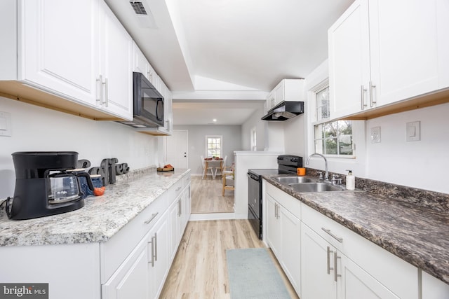 kitchen featuring white cabinets, light wood-style flooring, black appliances, and a healthy amount of sunlight