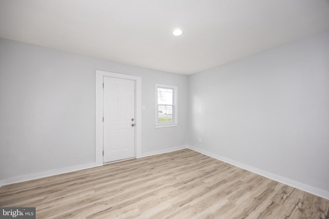 spare room featuring light wood finished floors, baseboards, and recessed lighting