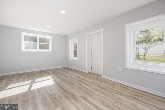spare room with baseboards, recessed lighting, and light wood-style floors