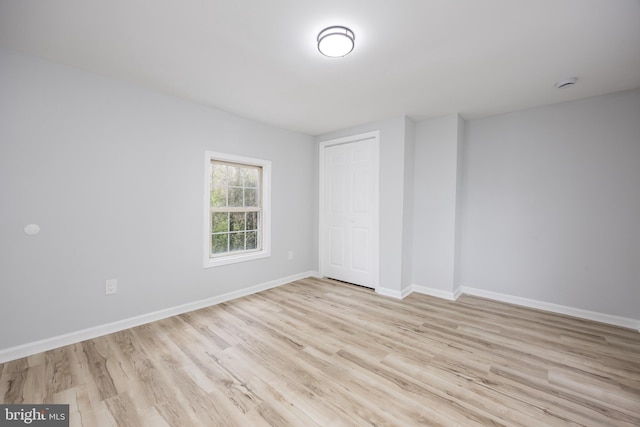 unfurnished bedroom featuring a closet, baseboards, and wood finished floors
