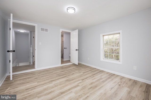 unfurnished bedroom featuring visible vents, light wood-type flooring, and baseboards