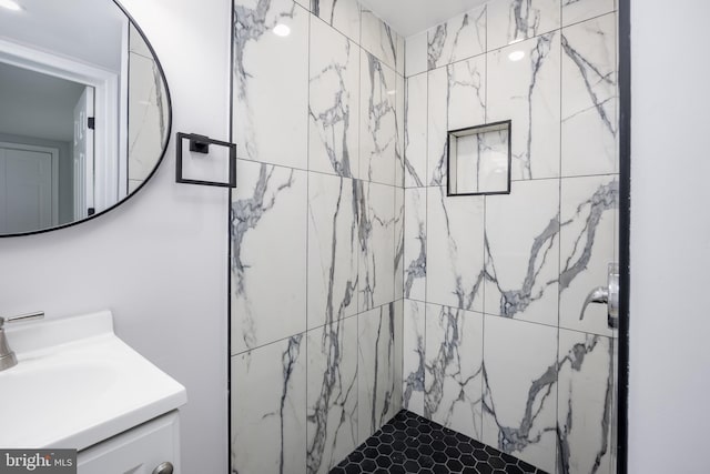 full bathroom with tiled shower and vanity