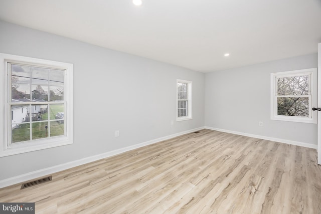 unfurnished room with visible vents, baseboards, light wood-type flooring, and recessed lighting