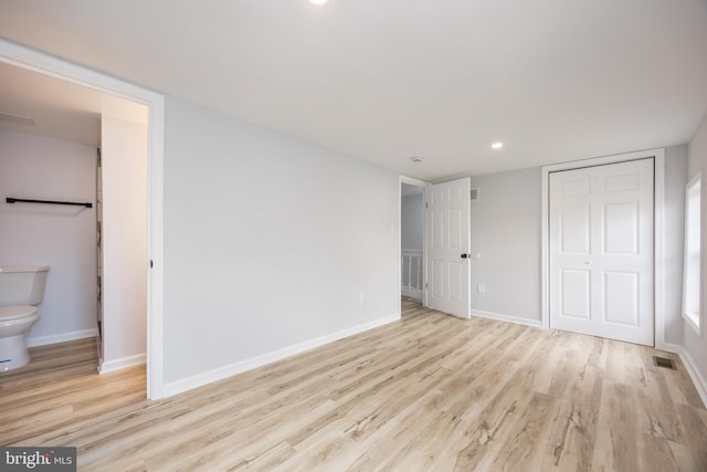 unfurnished bedroom with wood finished floors, a closet, and baseboards
