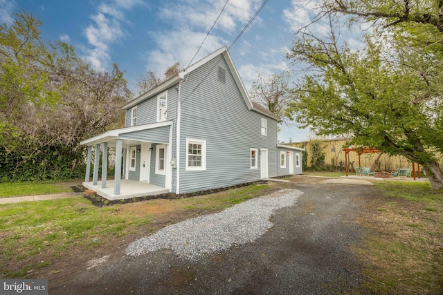 view of property exterior featuring covered porch and driveway