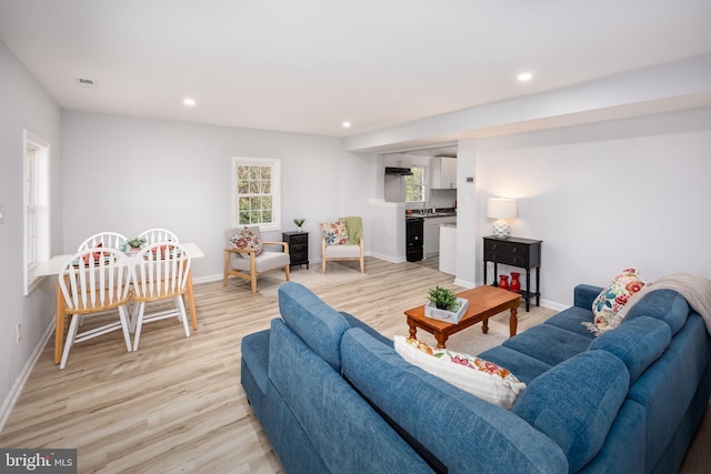 living area featuring light wood-style flooring, baseboards, visible vents, and recessed lighting