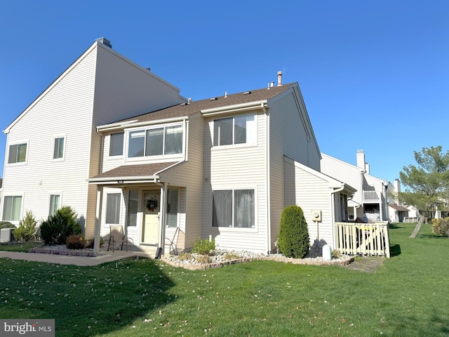 back of property featuring a lawn and a chimney