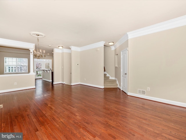 unfurnished living room with a chandelier, stairway, crown molding, visible vents, and wood finished floors