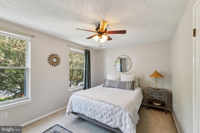 bedroom featuring baseboards, a ceiling fan, a textured ceiling, and light carpet
