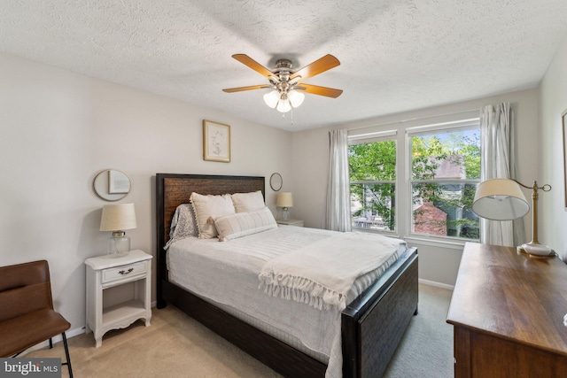 bedroom with light colored carpet, a textured ceiling, and baseboards