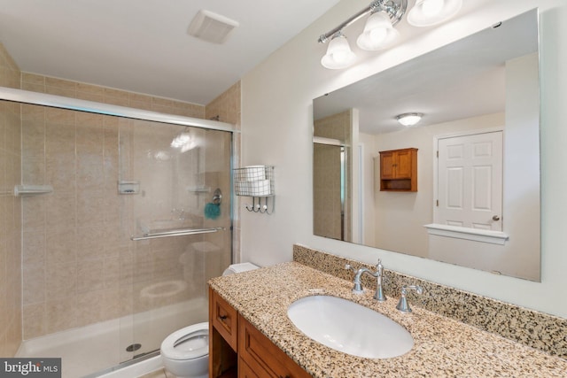 bathroom featuring visible vents, vanity, toilet, and a shower stall