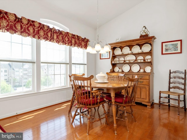 11110 Chambers Ct Unit N, Woodstock, MD 21163 - dining room with light wood-style floors, baseboards, lofted ceiling, and a notable chandelier
