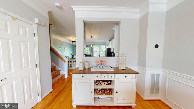 bar featuring visible vents, freestanding refrigerator, light wood-style floors, stairs, and ceiling fan