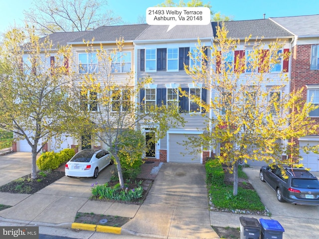 townhome / multi-family property with an attached garage, brick siding, and concrete driveway