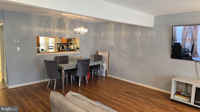 dining room featuring baseboards, a notable chandelier, and wood finished floors
