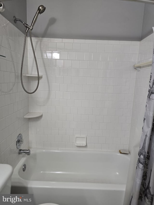 bathroom featuring shower / bath combo with shower curtain and toilet