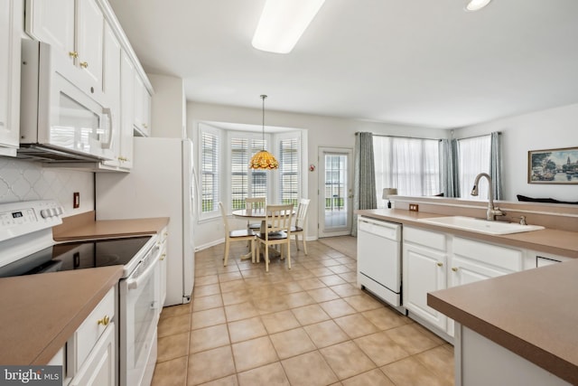 kitchen with decorative backsplash, white appliances, a sink, and a healthy amount of sunlight