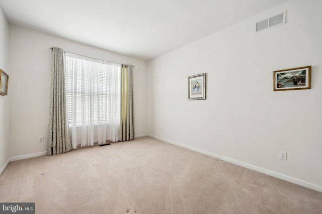 unfurnished room featuring visible vents, carpet flooring, and baseboards