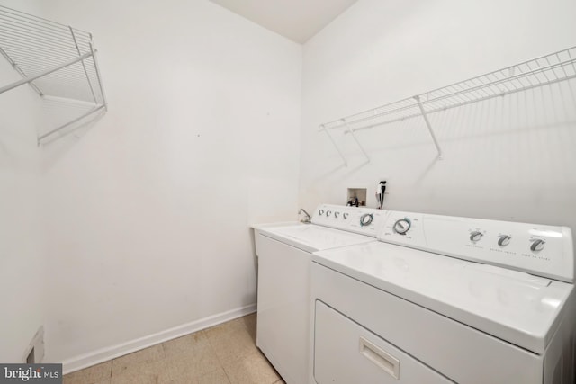 laundry room with washing machine and clothes dryer, laundry area, and baseboards