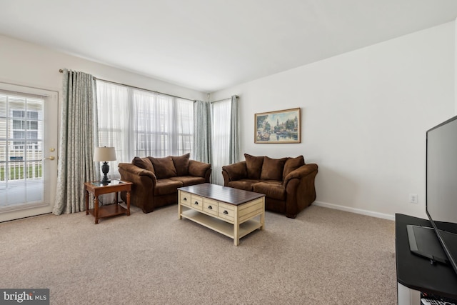 living room with light colored carpet, baseboards, and a healthy amount of sunlight