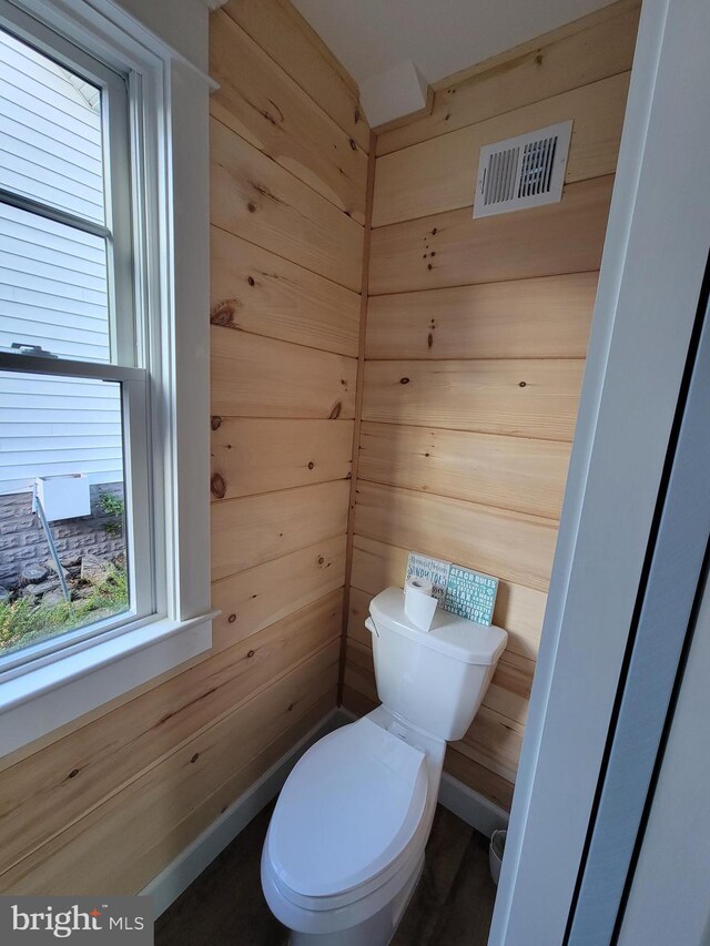 6555 Clagett Ave, Tracys Landing, MD 20779 - bathroom featuring wood walls, toilet, and visible vents