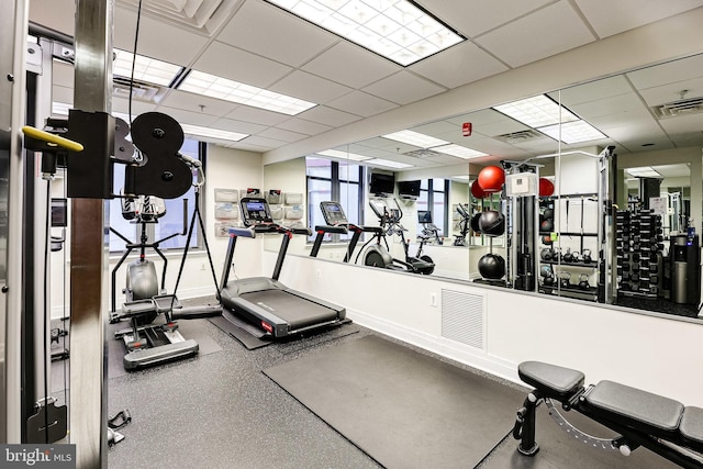 exercise room featuring visible vents, baseboards, and a drop ceiling