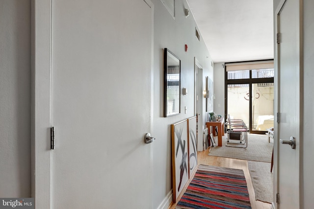 hall with baseboards and wood finished floors