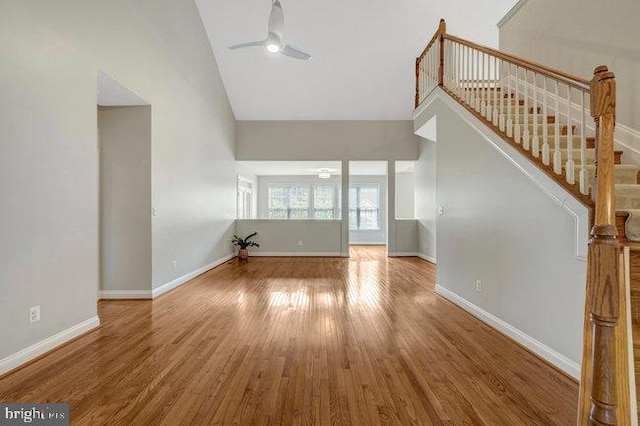 13404 Fieldstone Way, Gainesville, VA 20155 - unfurnished living room with a ceiling fan, wood finished floors, stairway, baseboards, and high vaulted ceiling