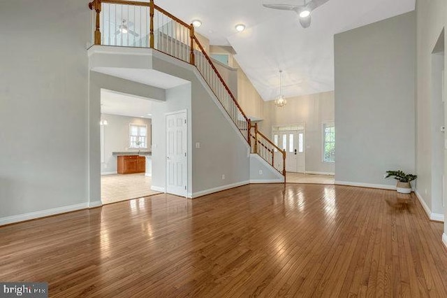 13404 Fieldstone Way, Gainesville, VA 20155 - unfurnished living room with stairway, a high ceiling, hardwood / wood-style flooring, a chandelier, and ceiling fan