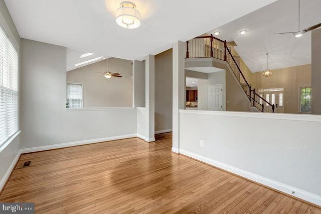13404 Fieldstone Way, Gainesville, VA 20155 - unfurnished living room featuring a ceiling fan, baseboards, wood finished floors, stairs, and high vaulted ceiling