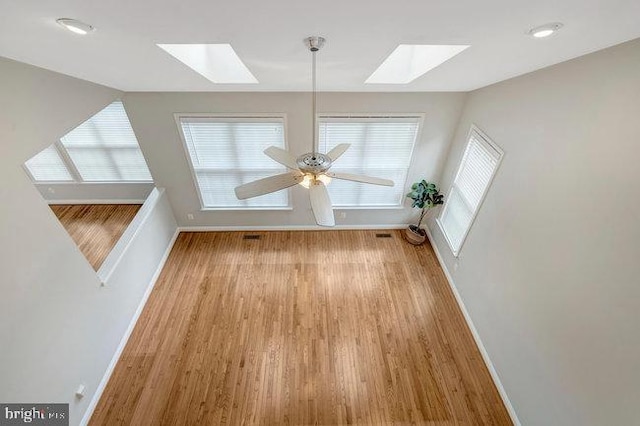 13404 Fieldstone Way, Gainesville, VA 20155 - unfurnished dining area featuring a skylight, wood finished floors, baseboards, and ceiling fan