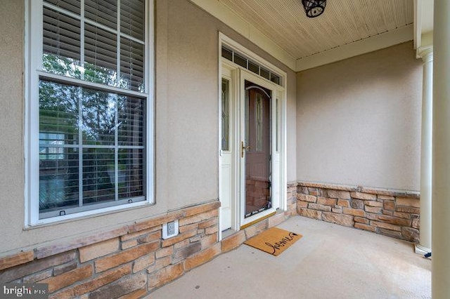 13404 Fieldstone Way, Gainesville, VA 20155 - view of exterior entry featuring stucco siding, a porch, and stone siding
