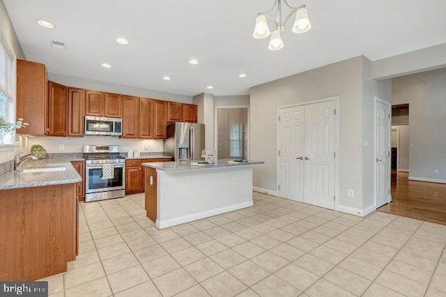 13404 Fieldstone Way, Gainesville, VA 20155 - kitchen with stainless steel appliances, a sink, light tile patterned floors, a center island, and a chandelier