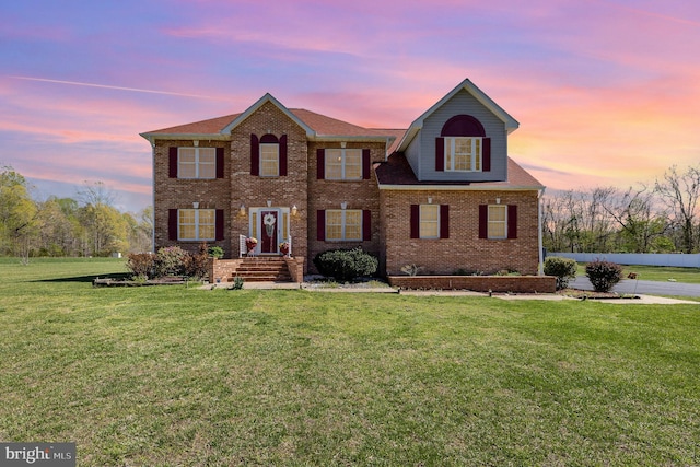 view of front of property with a front lawn and brick siding