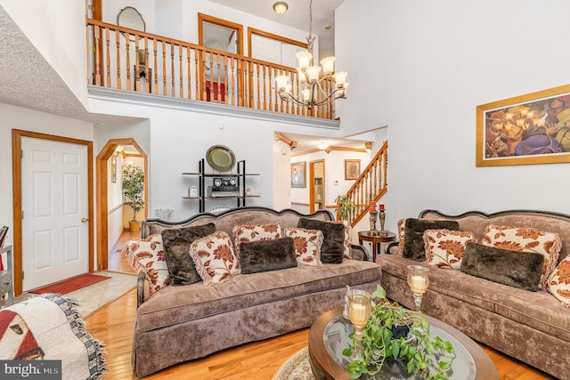 living area featuring a high ceiling, an inviting chandelier, and wood finished floors