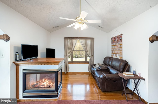 interior space with visible vents, lofted ceiling, wood finished floors, and a textured ceiling